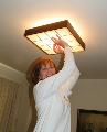 Barbara Harriman puts back the light fixture after changing a light bulb.