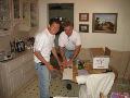 Benito Solorzano and Frank Conrad install a portable airconditioner for a senior homeowner.