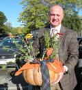 Steve Guzzetti poses for a photo before he loads his pumpkin and flower arrangement into his car.