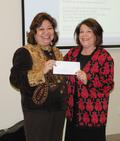 Equal Opportunity Committee Chair Tess Crescini presents proceeds from the Committee's Heritage Appreciation Potluck Mixer to Charitable Foundation Chair Carolyn Miller.