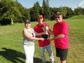 Suzanne Yost hands Team 650 captains Tim Anderson and Paul Skrabo the trophy.
