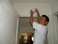 Perry Wong replaces a smoke detector battery.