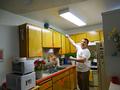 Removing cobwebs from above the cabinets.