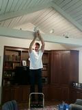 Alex Comsa changing a light bulb for a senior homeowner