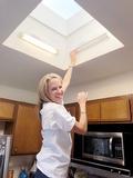 Ashley Banks changes a fluorescent bulb.