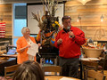 Suzanne Yost assists as auctioneer Mike Jacobi, entices members to bid on the huge fall display donated by Coldwell Banker offices of managing brokers Shawn Carroll (Saratoga) and Doug Evans (Los Gatos).