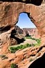 Vista beneath natural bridge in rock wall, Canyon del Muerto, Arizona