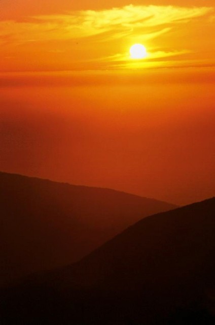 Sun drops low beyond Big Sur ridges, Big Sur, California