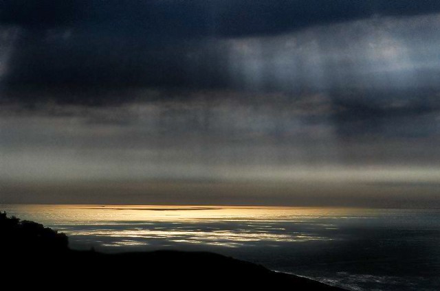 Golden sea and black clouds, Big Sur, California