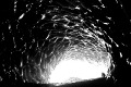 Glaciologist kneels at mouth of ice cave (#2, horizontal)... Mt. Ranier National Park, Washington