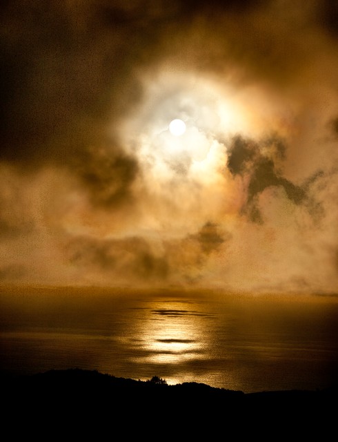 Sun burns through storm clouds, Big Sur, California