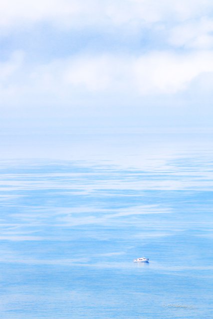 A Lonely Vessel Bobs on a Turquoise Sea