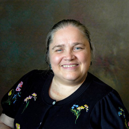 Pam Kennedy, hair pulled back, smiles in an author photo.